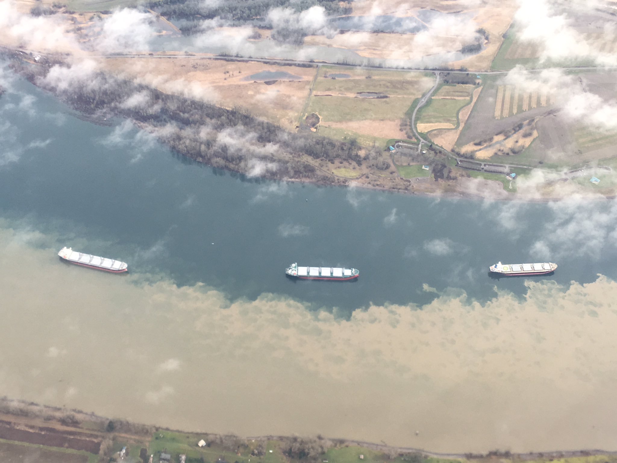 Brown soil enters the water of the Columbia river
