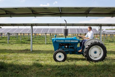 Byron Kominek, owner of Jack’s Solar Garden in Longmont, Colo., drives a tractor away following a kickoff event for the farm.