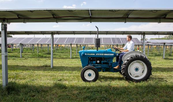 Byron Kominek, owner of Jack’s Solar Garden in Longmont, Colo., drives a tractor away following a kickoff event for the farm.